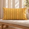 Cojín de sofá rectangular PALOMA amarillo 30 x 50 cm sobre una banqueta