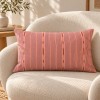 Cuscino da divano rettangolare PALOMA rosa 30 x 50 cm su una poltrona