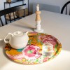 Plateau rond PAJARO Ø 45 cm avec une théière et un verre, sur une table