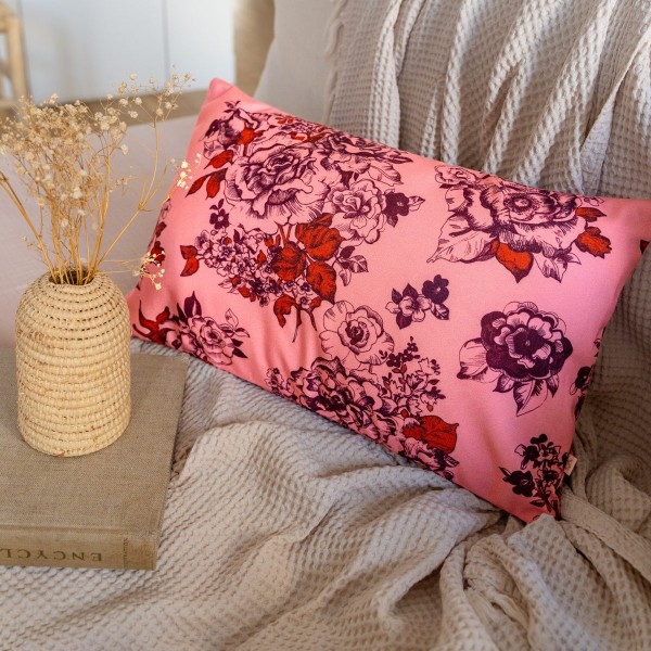 AIMI pink rectangular scatter cushion 30 x 50 cm on a sofa beside a vase of dried flowers